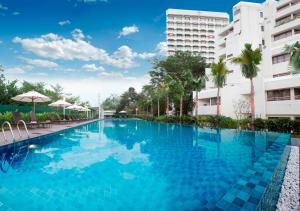 une grande piscine en face de deux bâtiments dans l'établissement Dorsett Grand Subang Hotel, à Subang Jaya