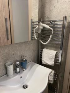 een badkamer met een wastafel, een spiegel en handdoeken bij Le Bijou Luxury Rooms & Suites in Veria