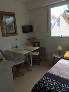 a room with a desk and a bed and a window at Studio Cosy in Wissant