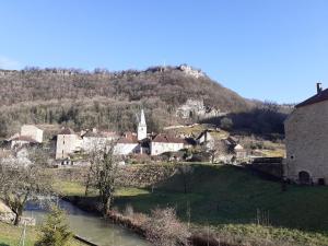 un pequeño pueblo con una iglesia en una colina en Gite Le bout du monde, en Baume-les-Messieurs