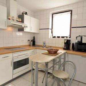 a kitchen with a table and two chairs in it at Apartmenthaus Spreewaldperle in Burg