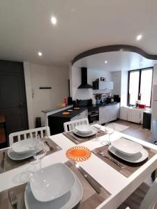 a kitchen with a table with plates and glasses on it at LE FERRETTE - Appartement moderne et confortable in Belfort