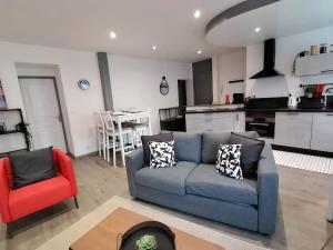a living room with a blue couch and a red chair at LE FERRETTE - Appartement moderne et confortable in Belfort