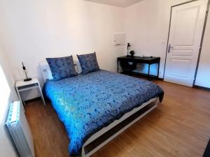 ベルフォールにあるGrand Appartement 2 chambres avec Fibre et Netflixのベッドルーム1室(青い掛け布団付きのベッド1台付)