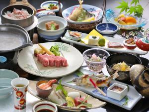 a table with many plates of food on it at Hotel Parens Onoya in Asakura