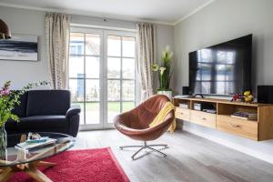 a living room with a couch and a chair and a television at Holiday house, Fuhlendorf in Fuhlendorf