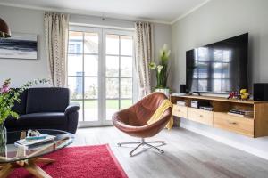 een woonkamer met een bank en een televisie bij Holiday house, Fuhlendorf in Fuhlendorf