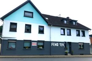un edificio azul y blanco con un cartel en él en FeWo194-Mint Im Herzen von Adenau/Nürburgring, en Adenau