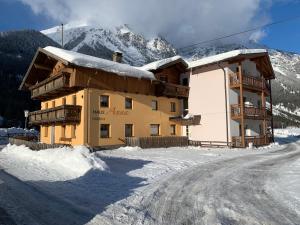 a building in the snow in front of a mountain at Haus Anna in Längenfeld