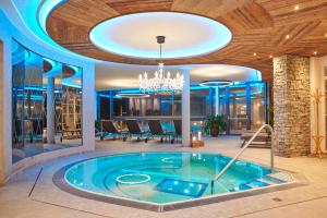 a hot tub in a room with a chandelier at Platzlhof - Mein Hotel im Zillertal in Ried im Zillertal