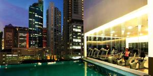 a view of a building with a pool and a city at Ramada Suites by Wyndham Kuala Lumpur City Centre in Kuala Lumpur