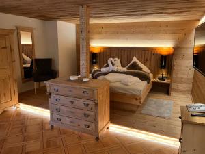 a bedroom with a bed and a dresser at Hotel Gasthof Adler in Sankt Gallenkirch