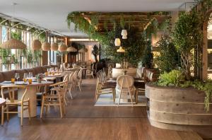 a restaurant with tables and chairs and plants at ME Barcelona in Barcelona