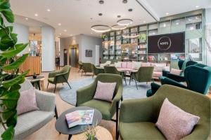 a waiting room with chairs and tables in a store at KOOS Hotel&Apartments - City Aparthotel in Munich