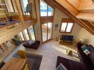 vistas panorámicas a una sala de estar con techos de madera en Alpenparadies en Beatenberg