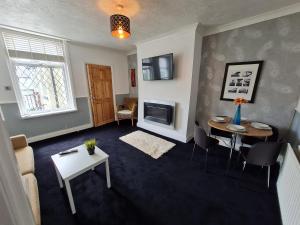 ein Wohnzimmer mit einem Tisch und einem Sofa in der Unterkunft Entire Premium Holiday Cottage in Monkwearmouth
