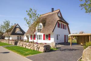 a white house with a thatched roof at Holiday house, Fuhlendorf in Fuhlendorf