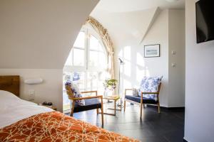 a bedroom with a bed and two chairs and a window at Holiday house, Fuhlendorf in Fuhlendorf