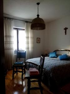 ein Schlafzimmer mit einem Bett, einem Stuhl und einem Fenster in der Unterkunft NUS-SCI-CASTELLO-ASTRONOMIA-CASINO' in Nus