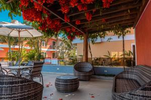 a patio with tables and chairs and an umbrella at Aquaville Apart Hotel in Porto Seguro