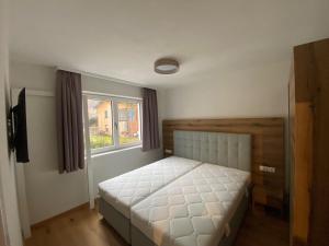 sypialnia z łóżkiem i oknem w obiekcie Sun Hill w Schladming