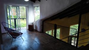 a room with a staircase with two chairs and windows at Zonda hostel cultural in Lago Puelo