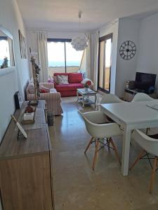 una sala de estar con una mesa y sillas en Penthouse 6-8 personnes, en Manilva 17 fotos más