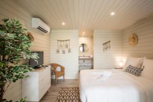 a bedroom with a white bed and a tv at Blue Sail Hotel in Anse Marcel 