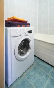 a white washing machine in a bathroom with a tub at Nice private room in a three room apartment Free parking Feel like at home in Vilnius +1 photo