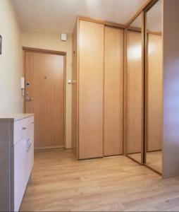 an empty room with wooden sliding doors in a room at Nice private room in a three room apartment Free parking Feel like at home in Vilnius