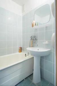 a white bathroom with a sink and a bath tub at Nice private room in a three room apartment Free parking Feel like at home in Vilnius