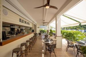 a restaurant with chairs and tables and a bar at Blue Sail Hotel in Anse Marcel 
