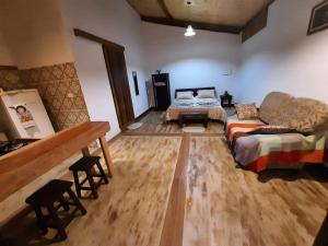 a living room with a couch and a bed at Chalé Filhos da Terra in São Francisco Xavier