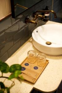 two glasses on a wooden cutting board next to a sink at Lamandau House in Jakarta