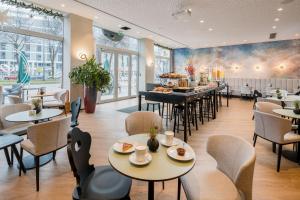 a restaurant with tables and chairs and a cafeteria at KOOS Hotel&Apartments - City Aparthotel in Munich