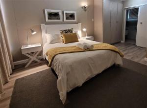 Un dormitorio con una cama grande y una mesa con una lámpara. en On The Beach At Strand en Strand