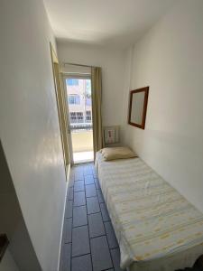 a bedroom with two beds in a room with a window at Pousada Morada das Nações in Balneário Camboriú