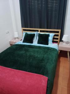 1 dormitorio con 1 cama verde grande y 2 almohadas en Apartamento en puerta valle Ricote y Archena en Villanueva de Río Segura