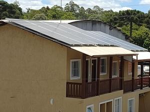 un edificio con paneles solares en el techo en Aluguel Por Temporada Jcl, en Gramado