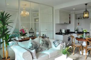 a living room with a white couch and a kitchen at Condo Hua Hin-Summer in Hua Hin