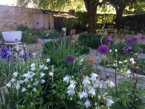 a garden with white and purple flowers at La Maison Forte in Revigny-sur-Ornain