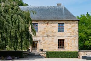 een groot bakstenen gebouw met een trap en een boom bij La Maison Forte in Revigny-sur-Ornain