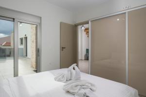 1 dormitorio con cama blanca y pared de cristal en Villa Jarko en La Canea