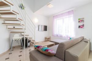 a living room with a couch and a staircase at Apartment Lovorka 5 in Baška