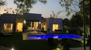 a villa with a swimming pool in front of a house at Villa Acacia in Orihuela Costa