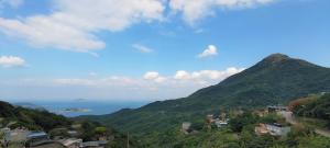 einen Blick auf einen Berg und das Meer im Hintergrund in der Unterkunft Camellia 2022 in Jiufen