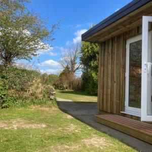 una vista lateral de una casa con una pasarela hacia una ventana en Woodpecker Glamping Cabin en Bodmin