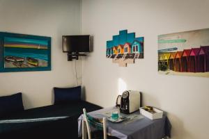 een kamer met een tafel en een tv aan de muur bij Affittacamere Simotta in Loano