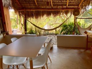 a dining room table with chairs and umbrellas at Posada La Sabila in Mazunte