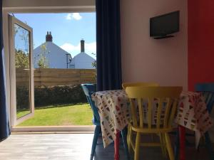 uma sala de jantar com uma mesa e cadeiras e uma janela em Woodpecker Glamping Cabin em Bodmin